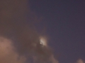 Moon hiding in the clouds at dusk